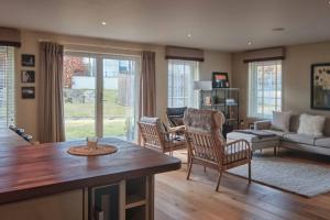 阿维莫尔The Steadings, Aviemore Luxury 5 star rated 3 Bed with home cinema garden and parking的客厅配有桌椅和沙发