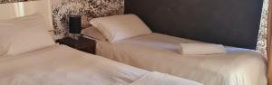 Pratola PelignaCasa vacanza da Anna 2的一间设有两张带白色床单的床的房间