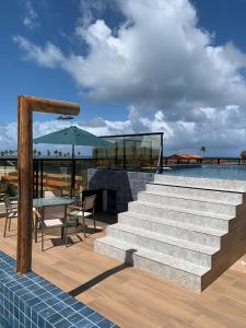 嘎林海斯港Pousada Atlantic的庭院设有楼梯、桌子和游泳池