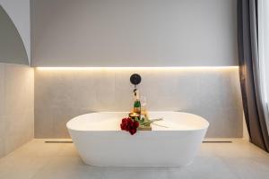 布达佩斯You Boutique Suites, Best Location by BQA的白色浴缸,配有一瓶香槟和鲜花
