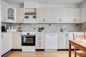 耶夫勒Vikingavägen 75的白色的厨房配有白色的橱柜和桌子