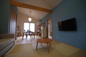 屋久岛SAKURA YAKUSHIMA的客厅配有沙发和墙上的电视