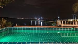 格兰岛เรือนตะวัน เกาะล้าน RueanTawan Kohlarn的游泳池在晚上有水
