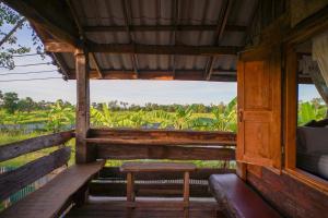 素可泰Suk Sabai Homestay的小木屋设有长凳和窗户。
