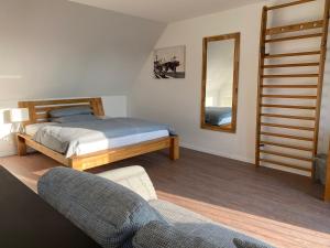 沃尔夫斯堡MEINpartments - Full service living的一间卧室配有一张床、一把椅子和镜子
