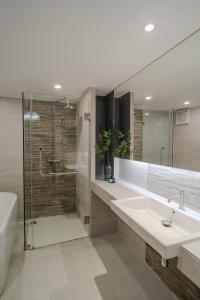 清迈Mini Jung Nimmari的浴室配有水槽、淋浴和浴缸。