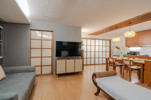 清迈Mini Jung Nimmari的带电视的客厅和用餐室