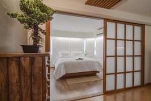 清迈Mini Jung Nimmari的一间卧室配有一张床和盆栽植物