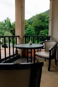 奥南海滩Aonang Knockout Hostel的阳台配有一张桌子和两把椅子