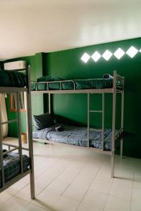 奥南海滩Aonang Knockout Hostel的绿色墙壁客房中的两张双层床