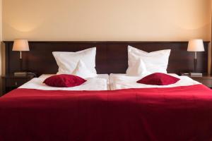 库多瓦-兹德鲁伊库多瓦放松工坊酒店的两张红色和白色的床,配有红色枕头