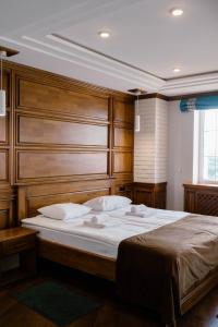 卡缅涅茨-波多利斯基塔拉斯布巴酒店的一间卧室配有一张大床和木制床头板