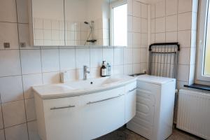不莱梅Volante Apartment Bremen-Findorff的白色的浴室设有水槽和镜子