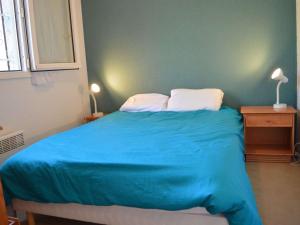 拉克鲁瓦瓦尔梅Appartement La Croix-Valmer, 2 pièces, 4 personnes - FR-1-226B-28的一间卧室配有蓝色的床和两个枕头