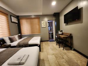大雅台Grayhouse Inn Tagaytay的酒店客房配有两张床和一张书桌