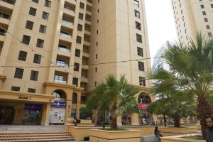 迪拜Shams JBR Hostel的一座棕榈树环绕的大建筑