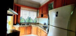 黑风洞Hilltop Greenview Residence Batu Caves Selayang的厨房配有木制橱柜和冰箱。