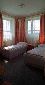 库特诺Sami Swoi Kutno的卧室设有两张床,配有红色窗帘和窗户