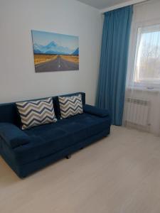 阿拉木图ЖК Palladium/41的客厅设有蓝色的沙发和窗户。