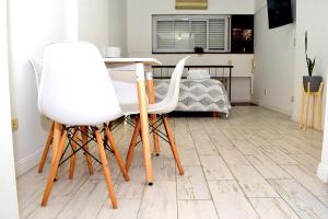 布宜诺斯艾利斯Estudio Petite Arroyo的客房内的2把白色椅子和1张桌子