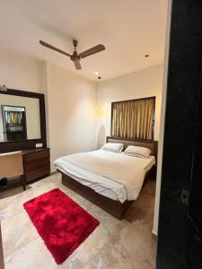 孟买Villa by the Sea的一间卧室配有一张床和红色地毯