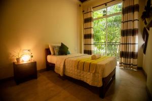 丹不拉Evergreen Hotel Dambulla的一间卧室设有一张床和一个大窗户