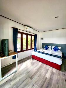 拉迈苏梅岛沙罗查别墅三棵树度假酒店的一间卧室配有一张带蓝色枕头的床和电视。