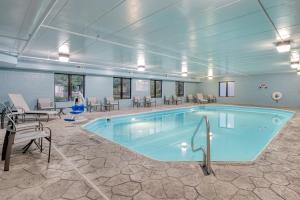 杰汉奈哥伦布机场智选假日套房酒店 的一个带桌椅的房间,一个大型游泳池