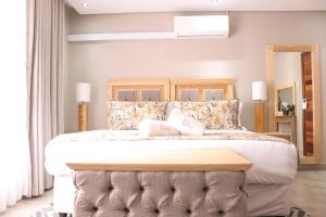 科克斯塔德EDEN BOUTIQUE HOTEL的一间卧室配有一张大床和木制床头板