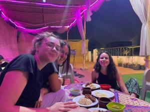 开罗Jana Pyramids view inn的一群坐在餐桌旁吃着食物的妇女