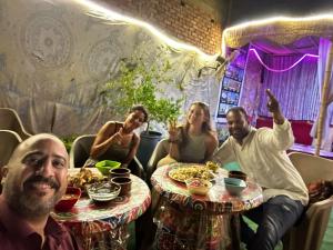 开罗Jana Pyramids view inn的一群人坐在餐桌旁吃着食物