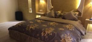 Al Khabrāʼشاليه غرناطة的一间卧室配有一张带棕色棉被的大床
