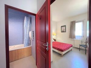 佩尔武Appartement Pelvoux, 2 pièces, 6 personnes - FR-1-330G-141的一道红色的门通向一间带床和浴缸的卧室