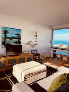 赞布热拉-杜马尔Sunset Beach House的带沙发和电视的客厅