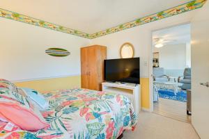 默特尔比奇Surfside Beach Condo with Balcony Walk to Beach!的一间卧室配有一张床和一台平面电视