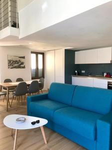马达莱纳Cala Gavetta mezzanine studio的客厅配有蓝色的沙发和桌子