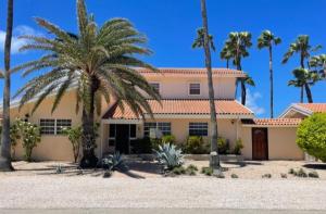 棕榈滩Beachside Villa at Boca Catalina的前面有棕榈树的房子