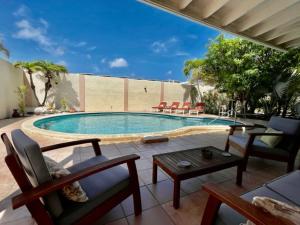 棕榈滩Beachside Villa at Boca Catalina的游泳池旁设有椅子和桌子