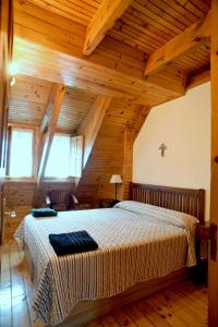 塞尔塞迪利亚La Casita de la Sierra Cercedilla的一间带一张大床的卧室,位于一个拥有木制天花板的房间