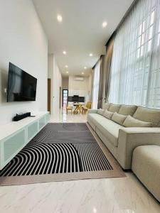 清莱HomeHug@ChiangRai的带沙发和平面电视的客厅