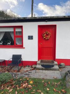 克利夫登The Potters Cottage的白色房子上一扇红色的门,有窗