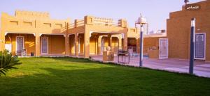 Al Khabrāʼشاليه غرناطة的前面有绿色草坪的建筑
