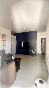 桑托斯将军城MESSÉ Home Stay的客厅设有蓝色墙壁和平面电视。