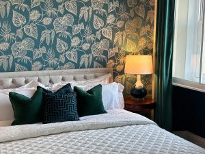 伯福德Burford Lodge Hotel - Adults only的一间卧室配有一张带花卉壁纸的床