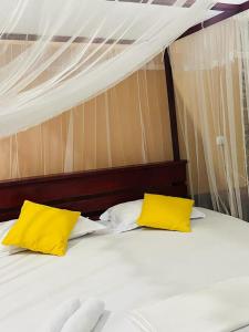 基图尔格勒Gallene Gala Nature Resort的床上有两张黄色枕头