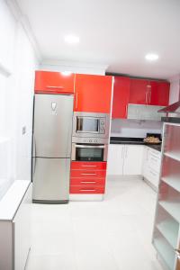 洛格罗尼奥El Balcón de Miguel的厨房配有红色橱柜和不锈钢冰箱