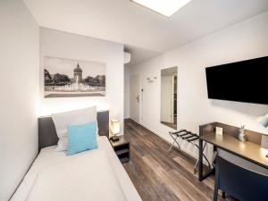 曼海姆Mood contemporary living的客房设有1张床、1张办公桌和1台电视。