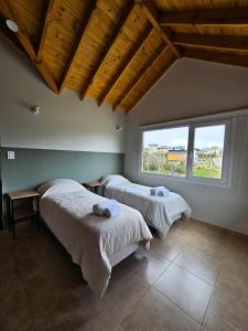 乌斯怀亚Comarca Fueguina的带大窗户的客房内的两张床