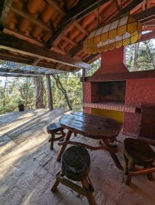 萨迈帕塔Rustic lodge Samaipata的门廊上的木桌和椅子