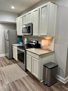 纽南2 BR 1 BA apartment的厨房配有白色橱柜和不锈钢冰箱
